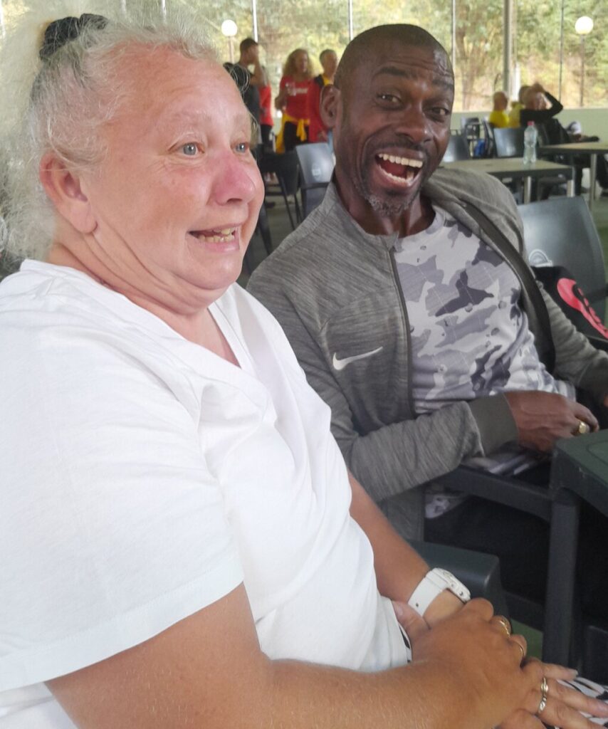 Lesley Richardson W55 enjoys a laugh with Joe Appiah M55 100m Hurdles champion and a late addition to the officials starting team at the presentation marquee